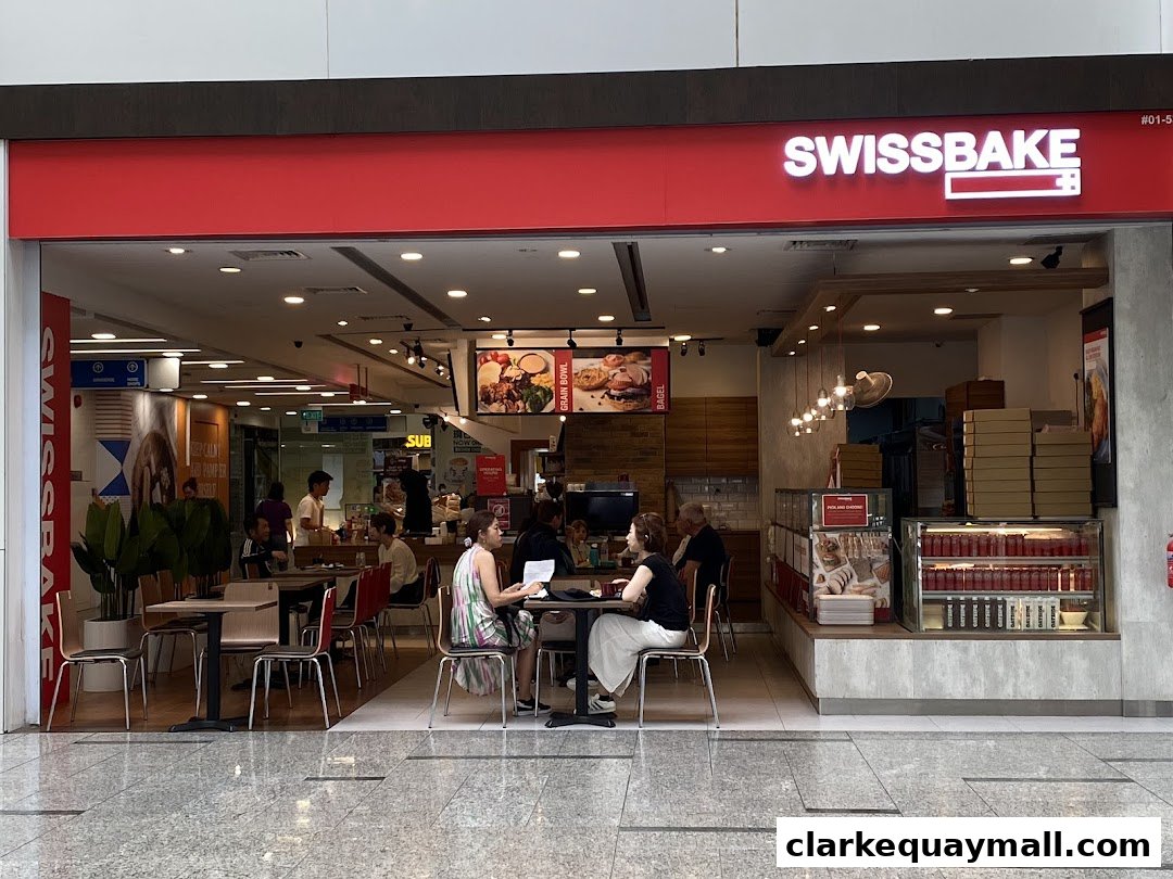 The exterior of Swissbake Cafe with customers seated inside and a prominent signage.