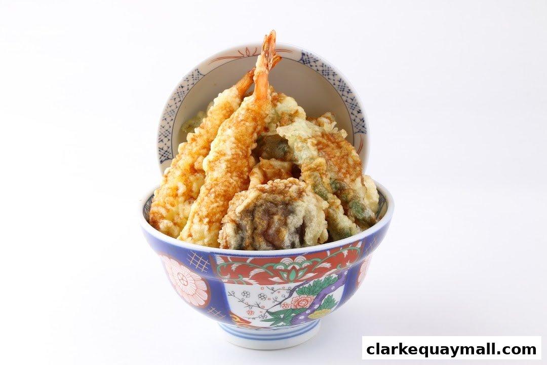A bowl of delicious tempura, featuring shrimp and vegetables, served in a decorative bowl.
