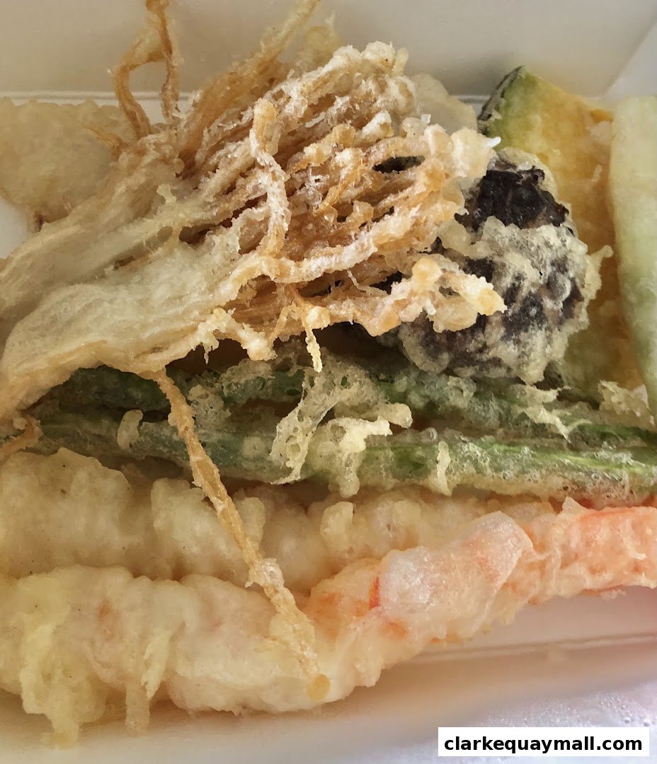 A close-up of a variety of crispy tempura dishes, including shrimp, vegetables, and mushrooms.
