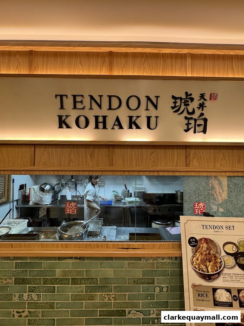 The entrance of Tendon Kohaku restaurant with a view of the kitchen and a menu displayed.