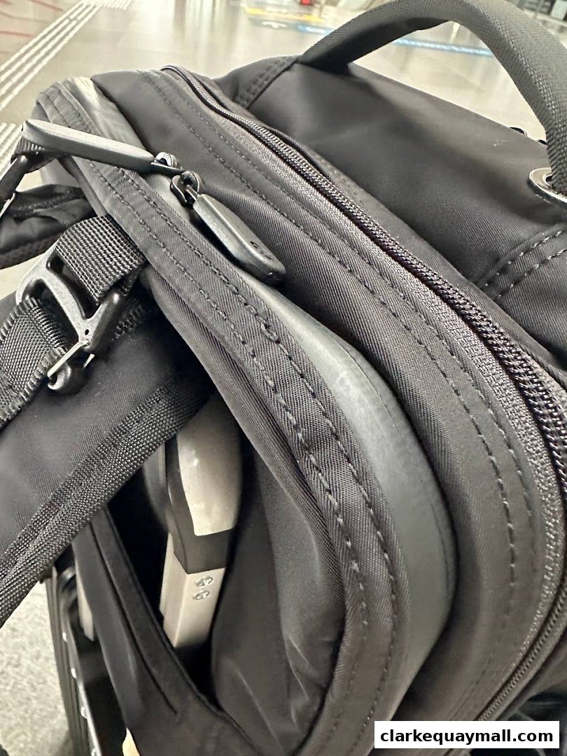 Close-up of a black bag with zippers and straps, showing its durable construction.