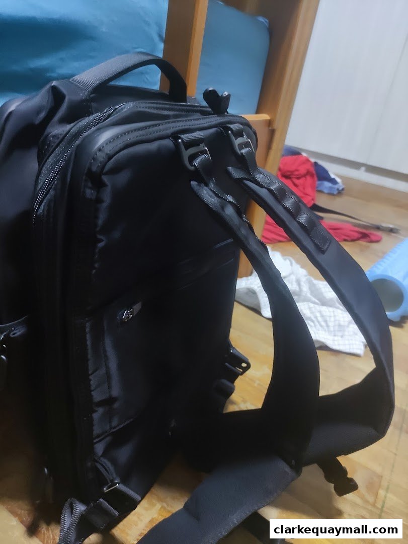 A close-up view of a black backpack with adjustable straps and zippers.