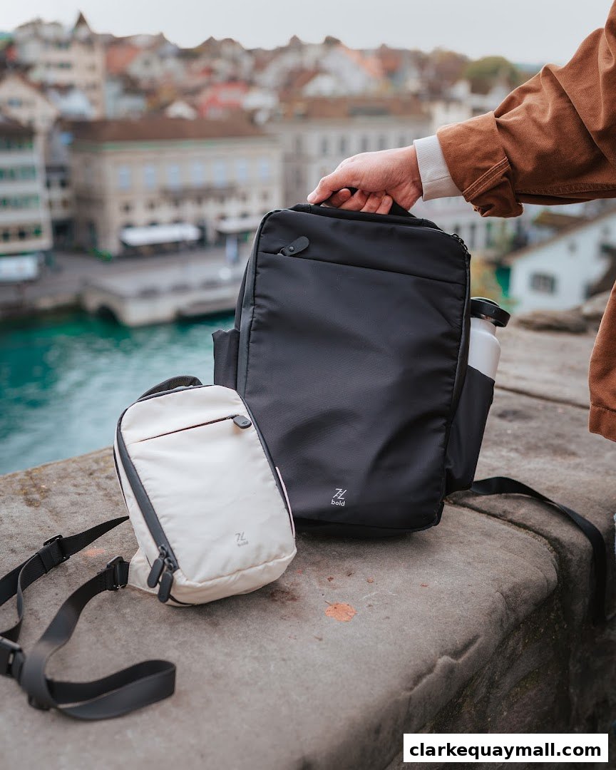 A hand holds a black backpack next to a cream-colored sling bag with a scenic city view in the background.