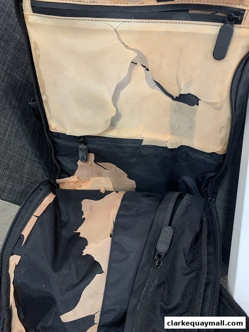 Interior of a black bag with damaged, peeling lining.