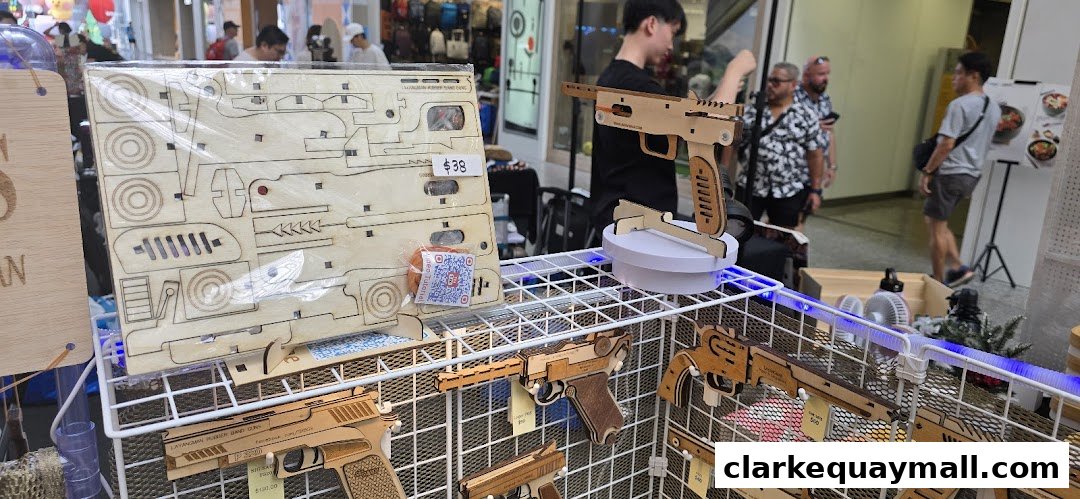 Wooden model guns and a DIY kit are displayed on a wire rack at a shop.