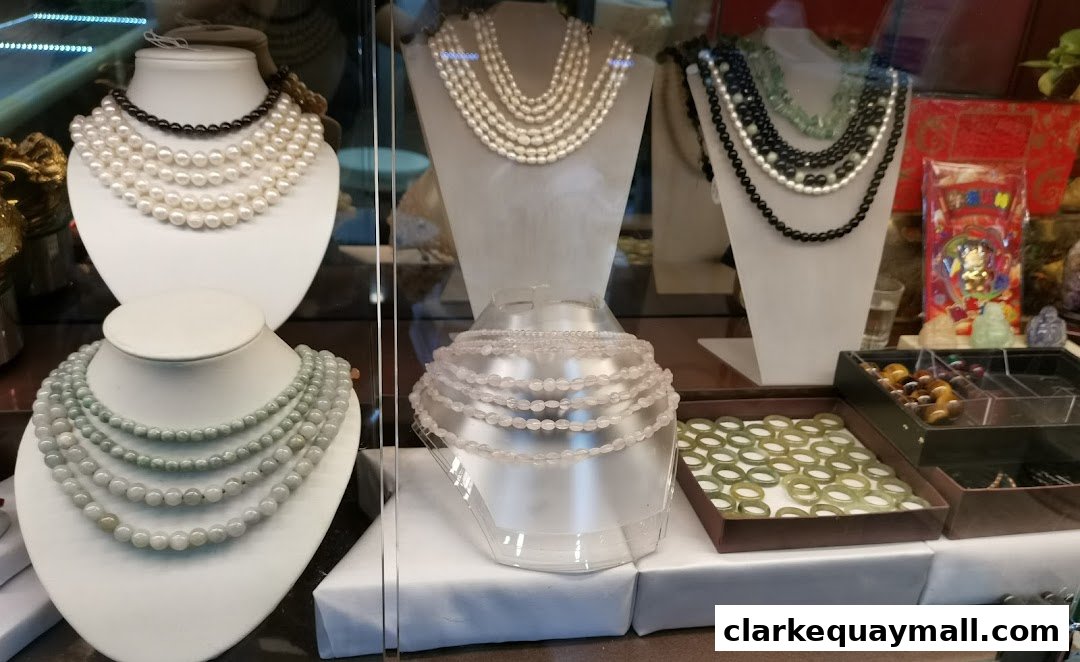 A display of various necklaces and bracelets made of pearls and jade.