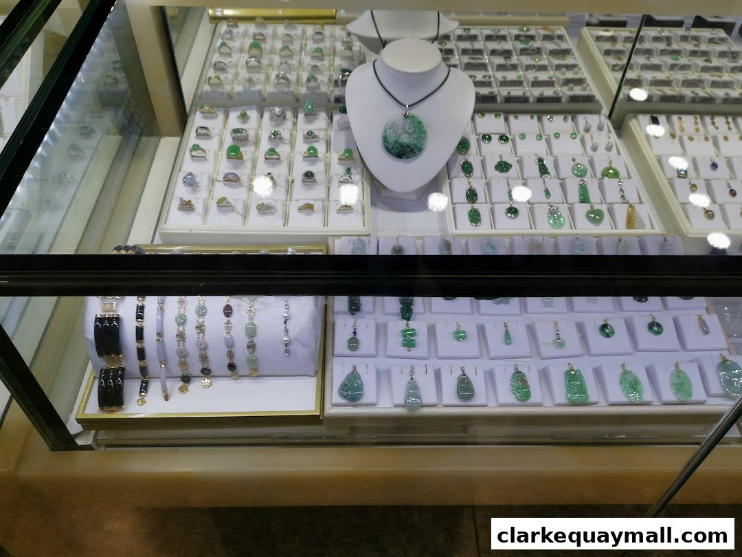 A display case filled with various jade jewelry, including pendants, rings, and bracelets.