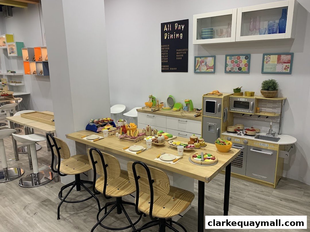 A play kitchen and dining area with toy food and a menu board.