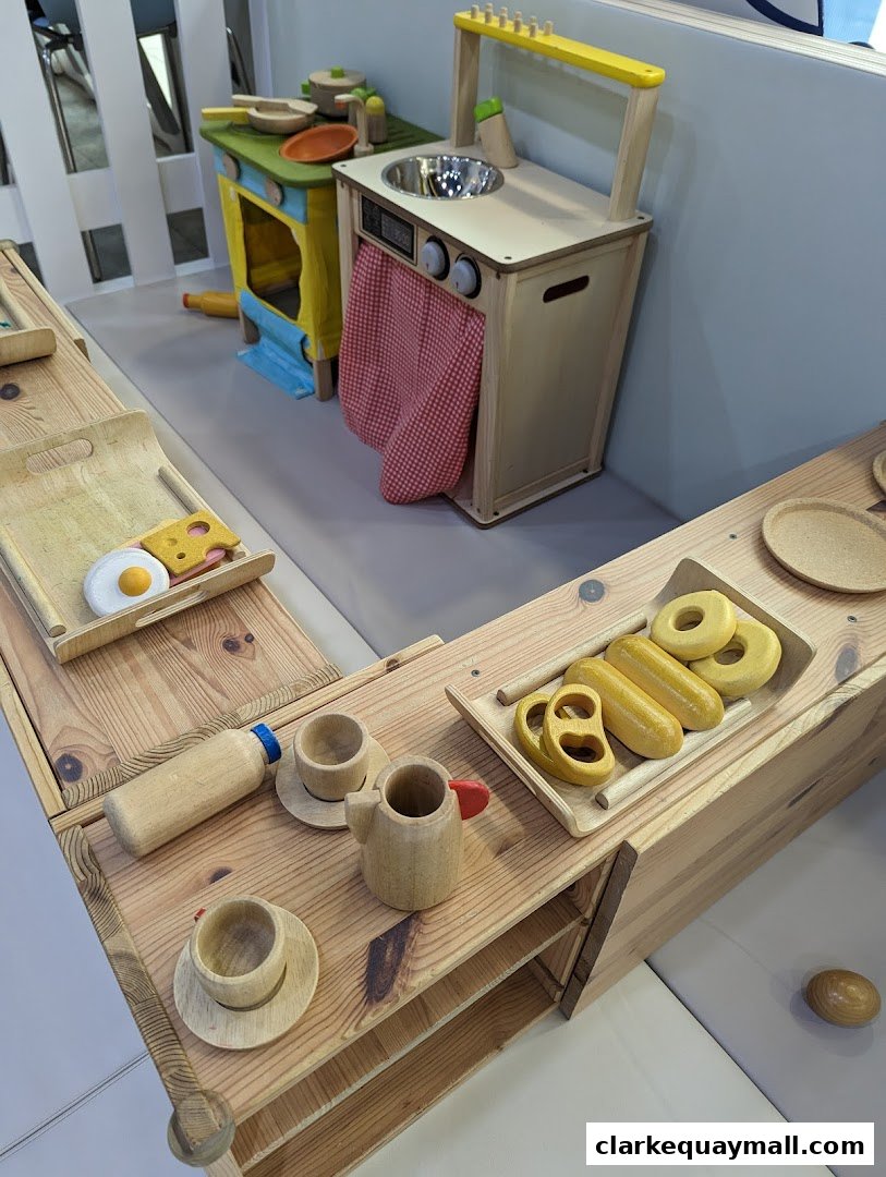 Wooden toy kitchen set with play food and accessories.