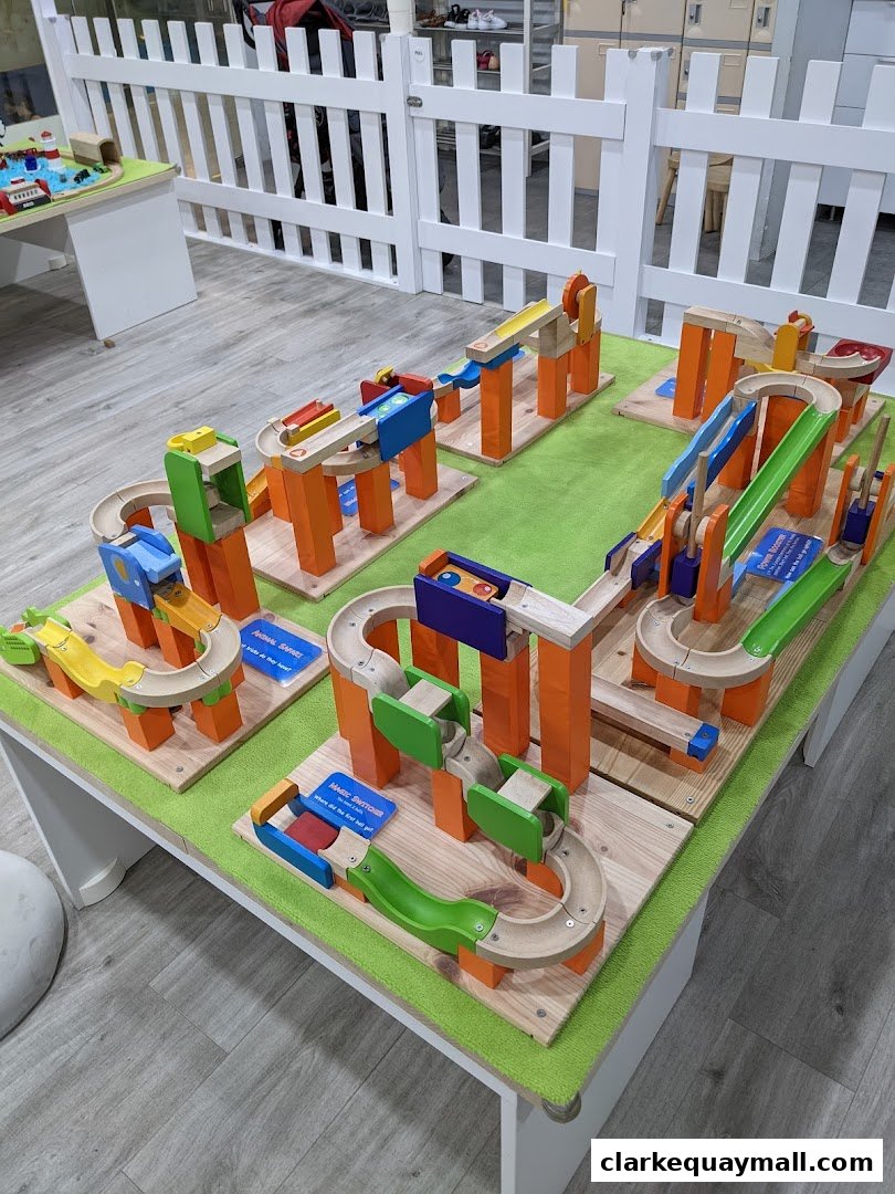 A table displaying colorful wooden marble run toys with various tracks and ramps.