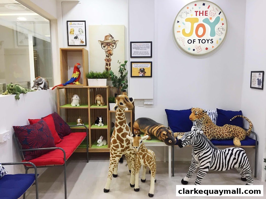 Interior of a toy store with plush animals, including giraffes, a zebra, a leopard, and a hippo.