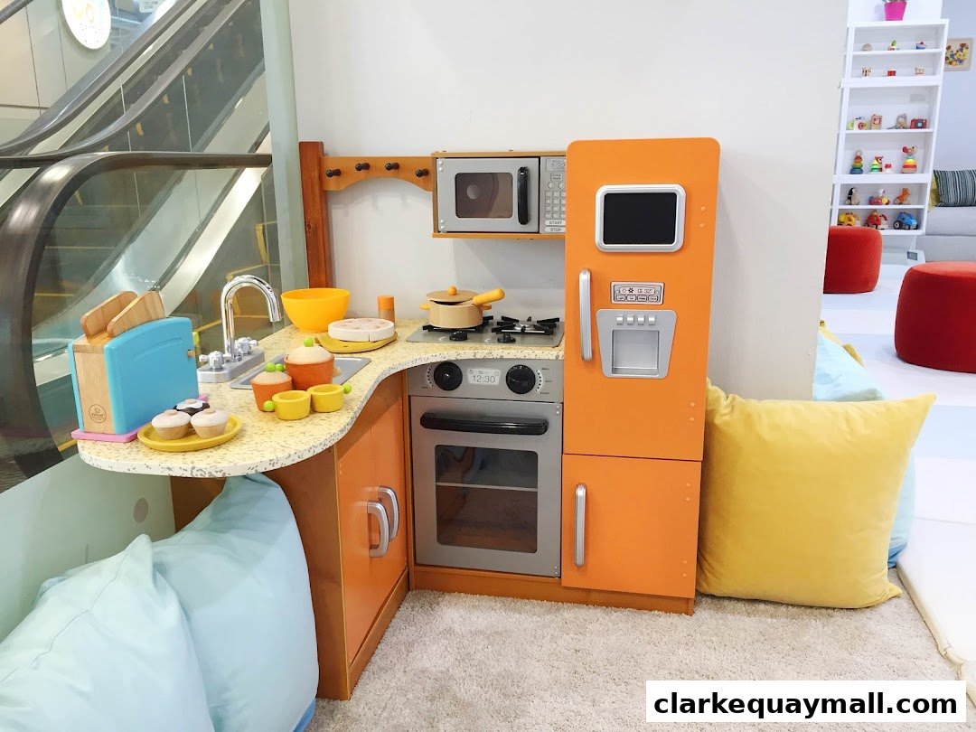 A colorful toy kitchen set with accessories, including a toaster, oven, and refrigerator.