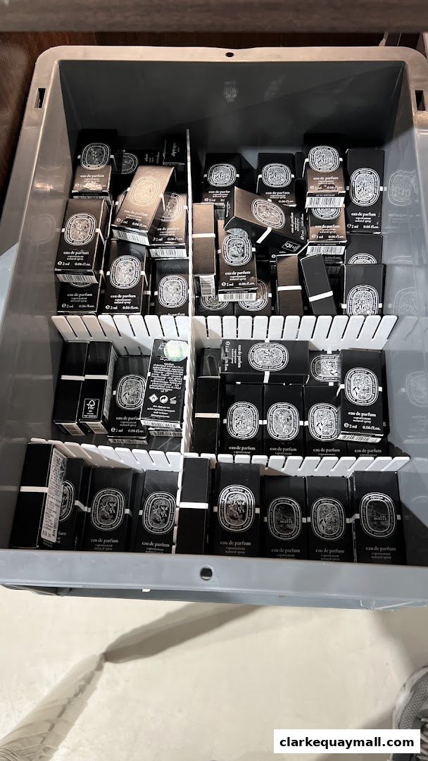 A bin filled with small black boxes of Diptyque eau de parfum.
