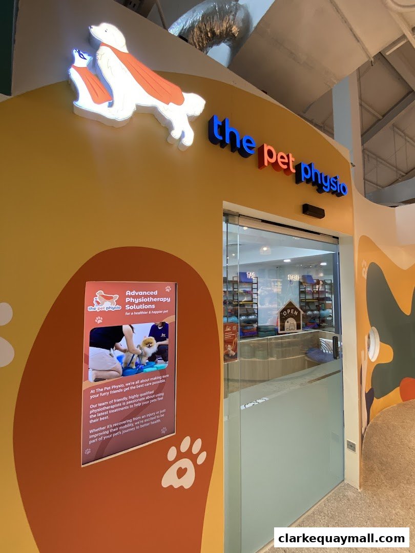 The entrance to 'The Pet Physio' shop, featuring its logo and an informational display.