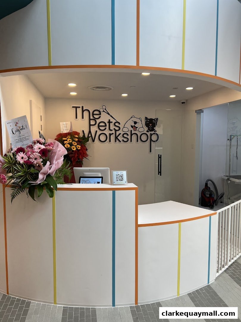 The reception counter of The Pets Workshop, a pet grooming salon, with floral decorations.