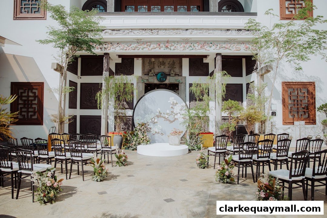 An outdoor seating area with chairs arranged for an event, featuring a decorative backdrop.
