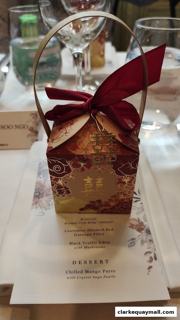 A festive gift box with Chinese characters sits on a table with a menu.