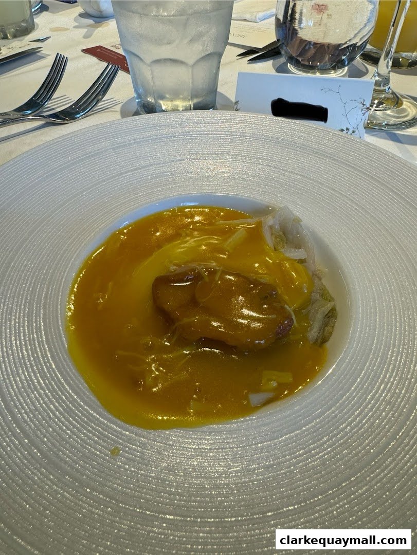 A close-up of a beautifully presented dish with a rich yellow sauce and a piece of meat.