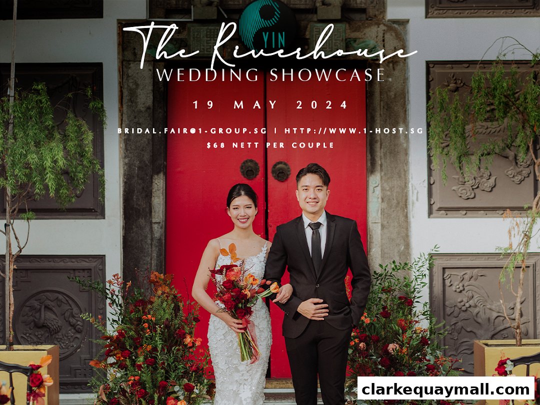 A couple poses in front of a red door at The Riverhouse Wedding Showcase.