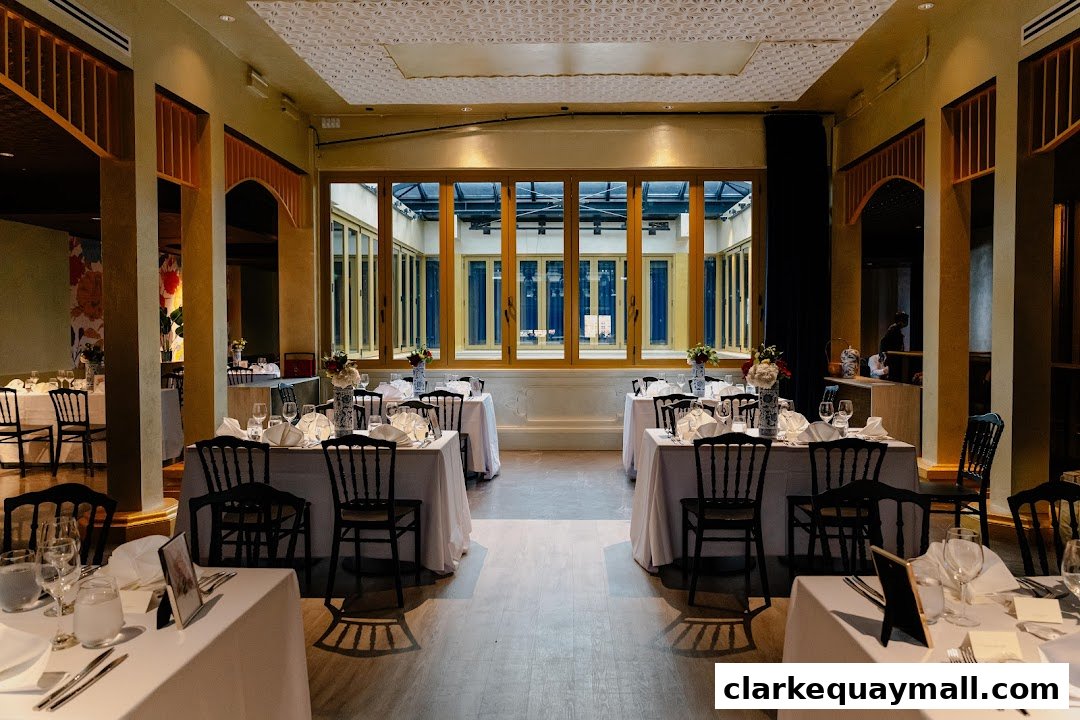 Elegant dining room with tables set for a special occasion, featuring floral centerpieces.
