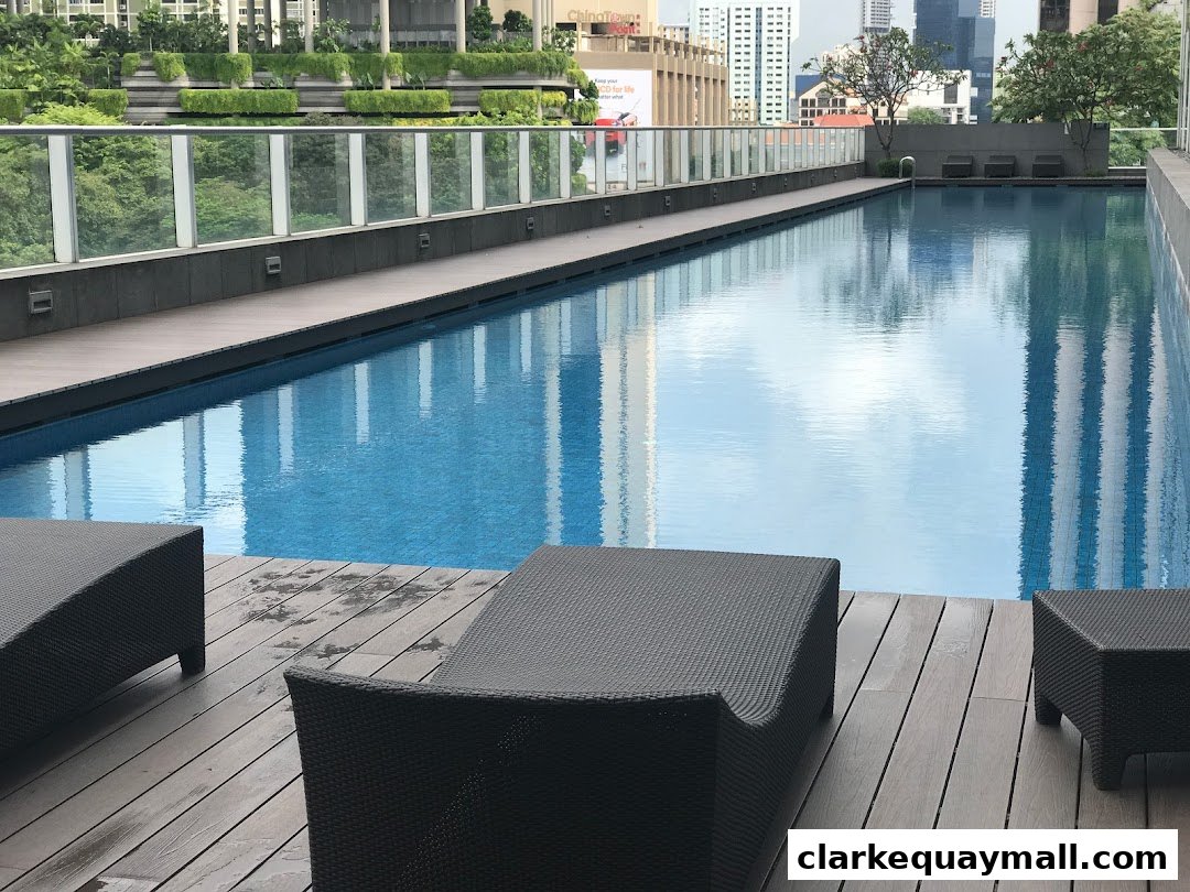 A rooftop swimming pool with lounge chairs and city skyline in the background.
