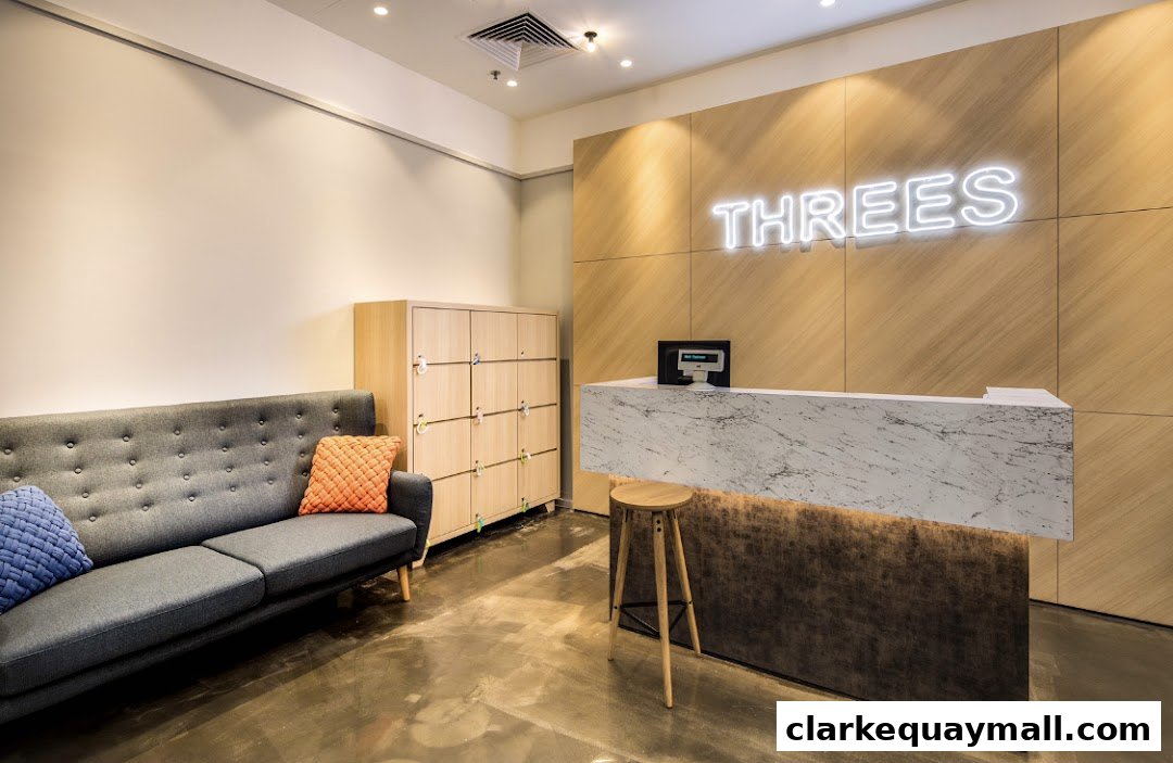 The reception area of THREES Beauty Salon features a modern marble counter, a comfortable sofa, and lockers.