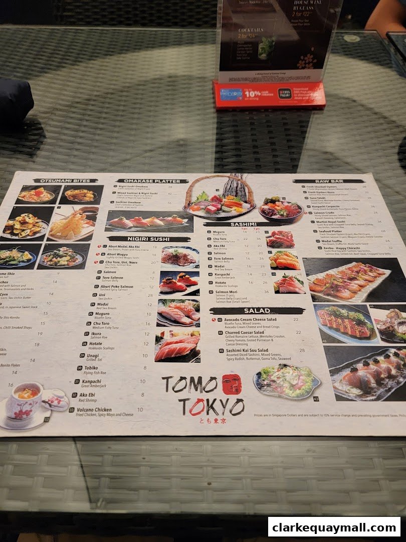 A menu from Tomo Tokyo featuring sushi, sashimi, and salads with accompanying images.