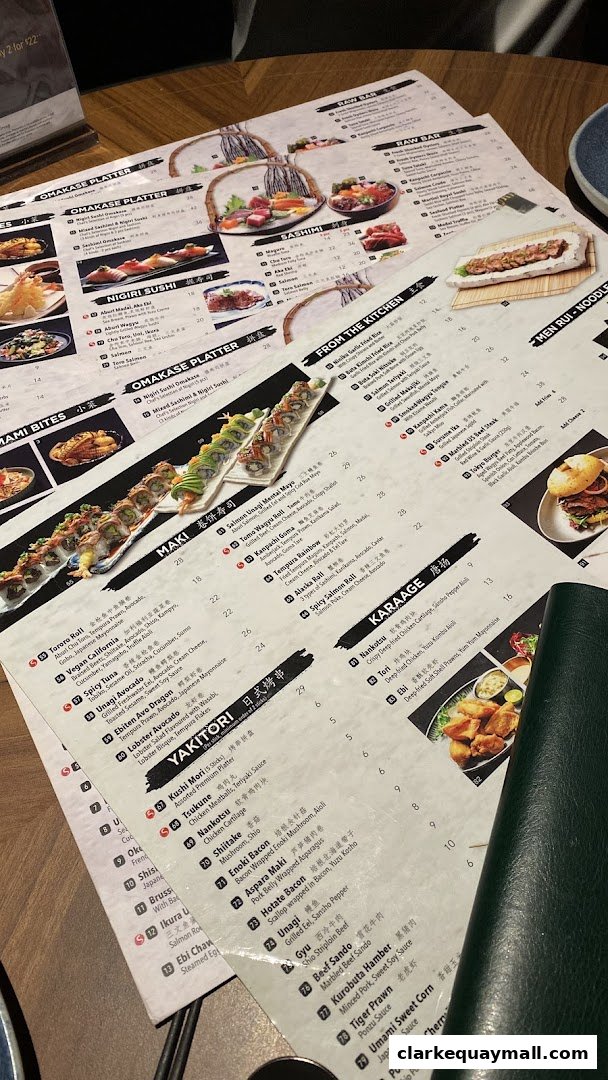 A close-up view of a Japanese restaurant menu with various sushi, maki, and yakitori options.