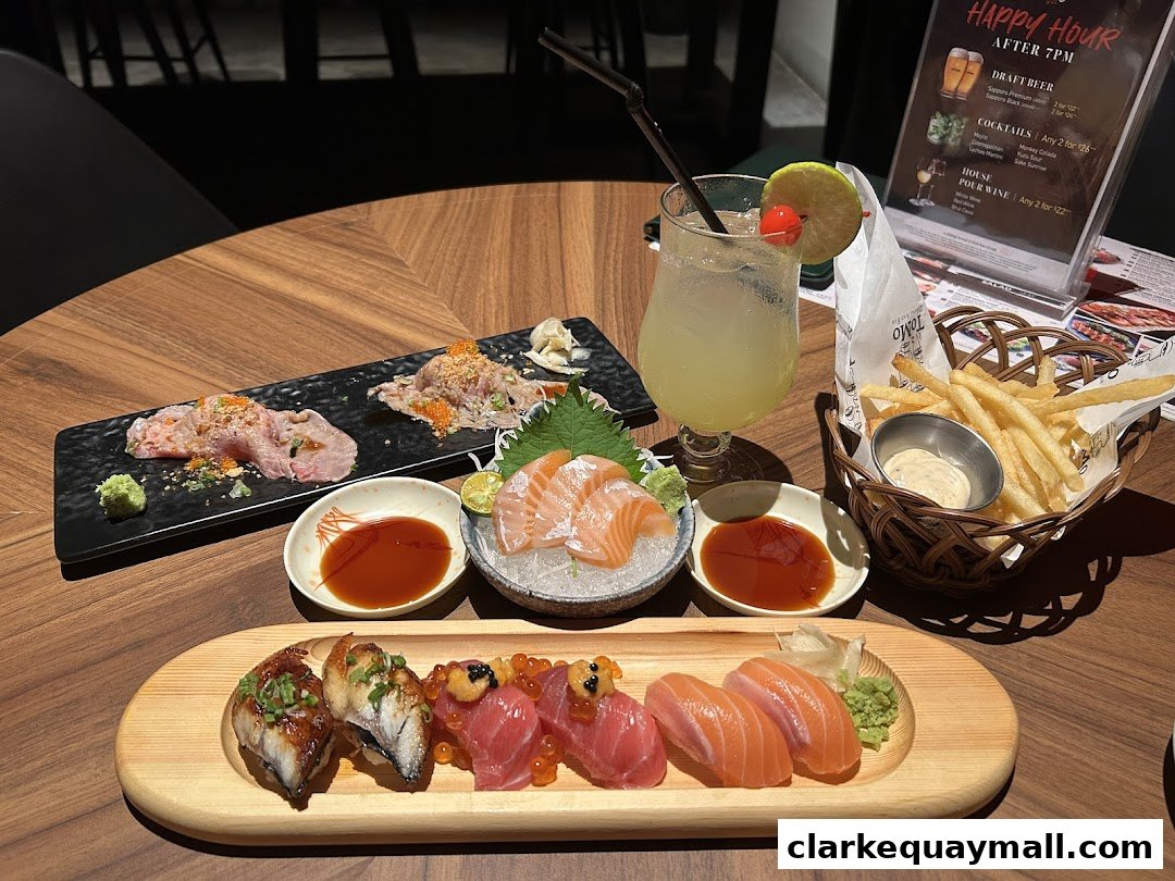 A table laden with Japanese food, including sushi, sashimi, fries, and a cocktail.