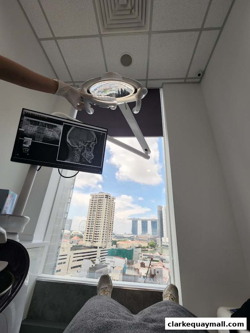 A dental examination room with a view of the city skyline and dental x-rays on a monitor.