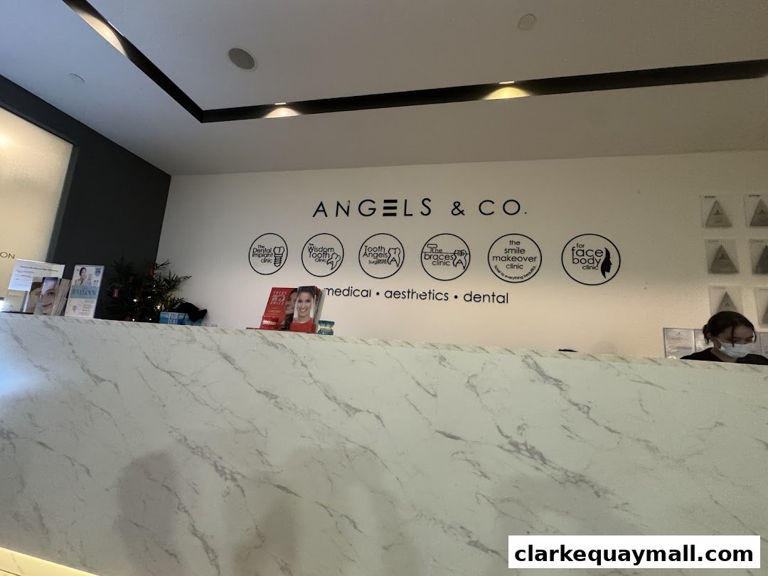 The reception area of TOOTH ANGELS Dental Surgeons, featuring the brand name and service icons.