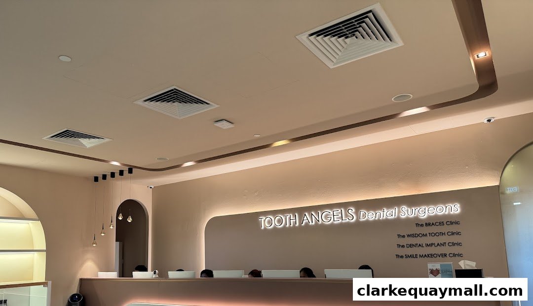 The reception area of Tooth Angels Dental Surgeons with a lit sign and staff behind the counter.