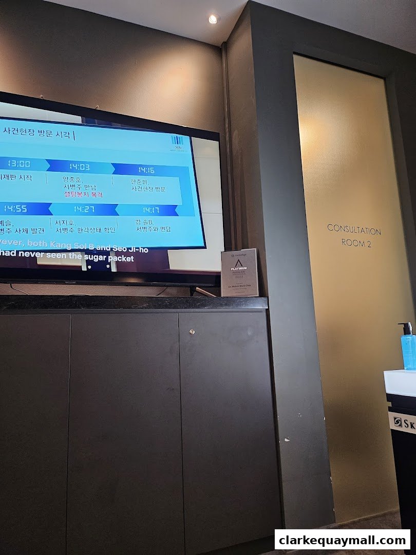 A screen displays appointment times and patient names, next to a consultation room door.