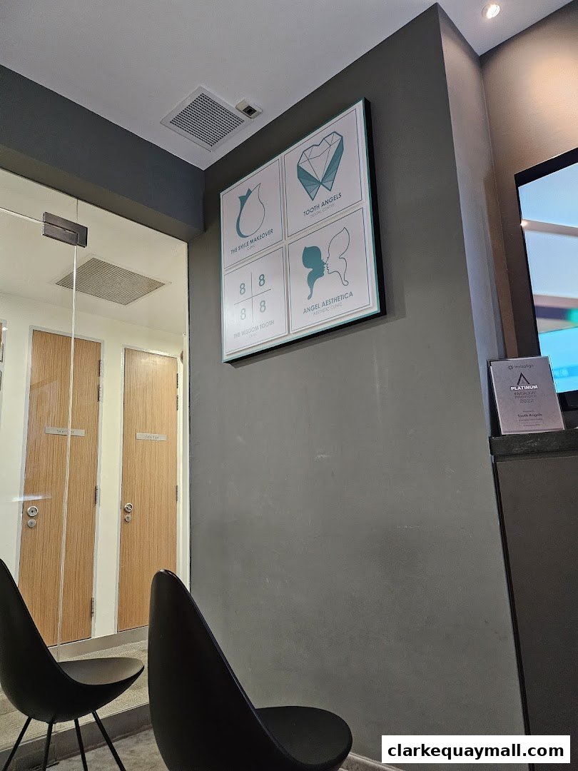 Interior waiting area of a dental clinic with chairs and informational posters on the wall.