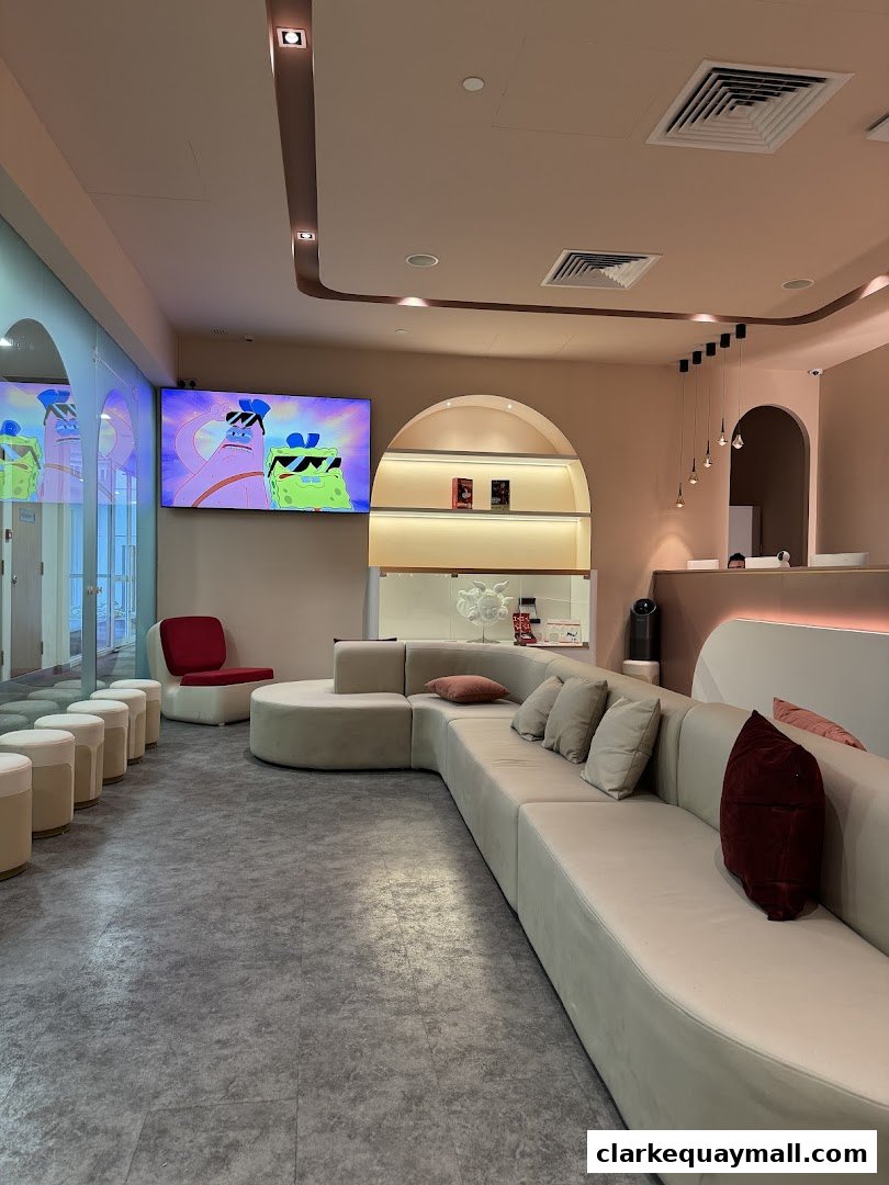 A modern waiting area with a large curved sofa, chairs, and a TV playing cartoons.