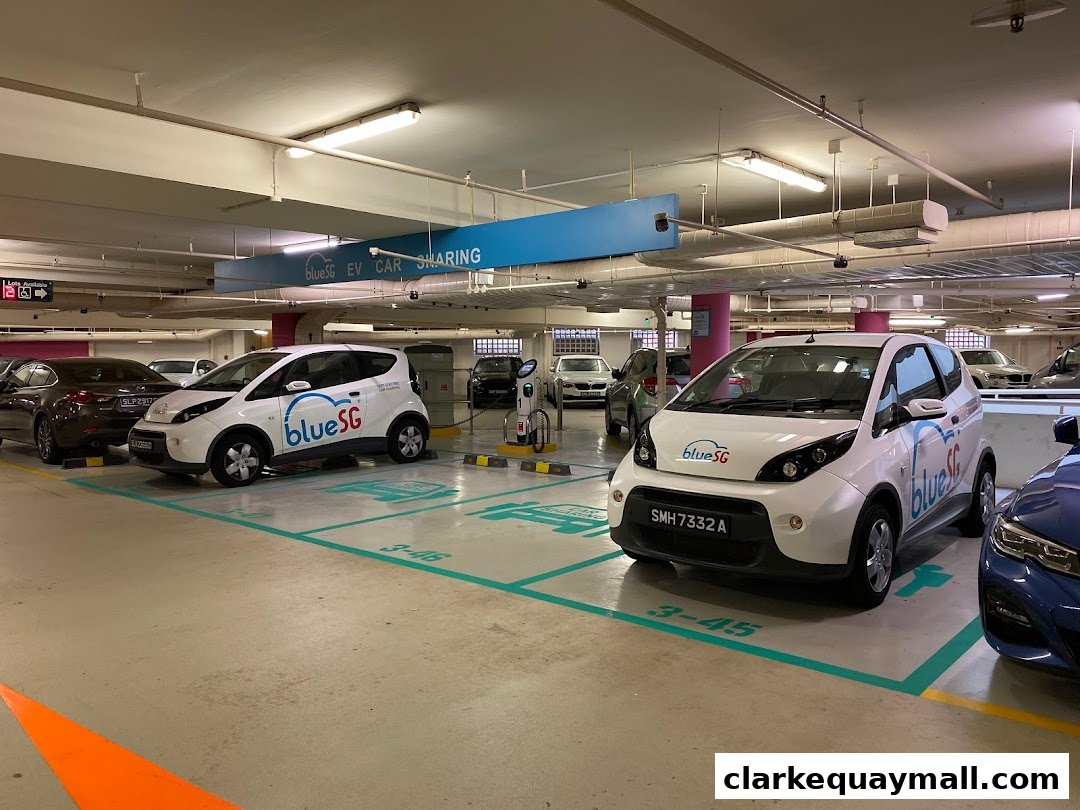 Electric cars parked in a charging station with signage for EV car sharing.