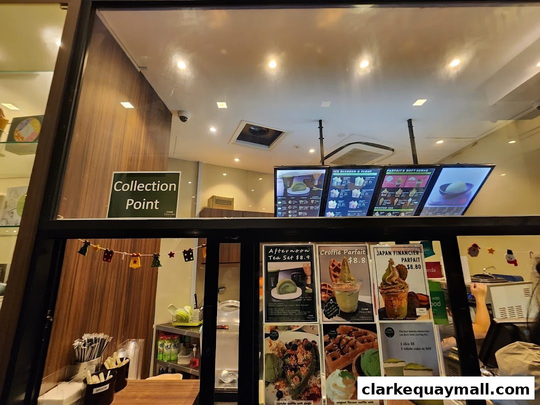 A view of a dessert shop counter with digital menus and displayed food items.