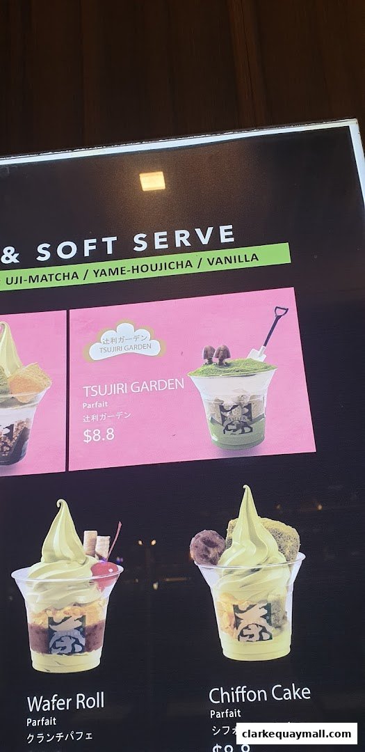 A menu board displaying various matcha parfaits and soft serve options.