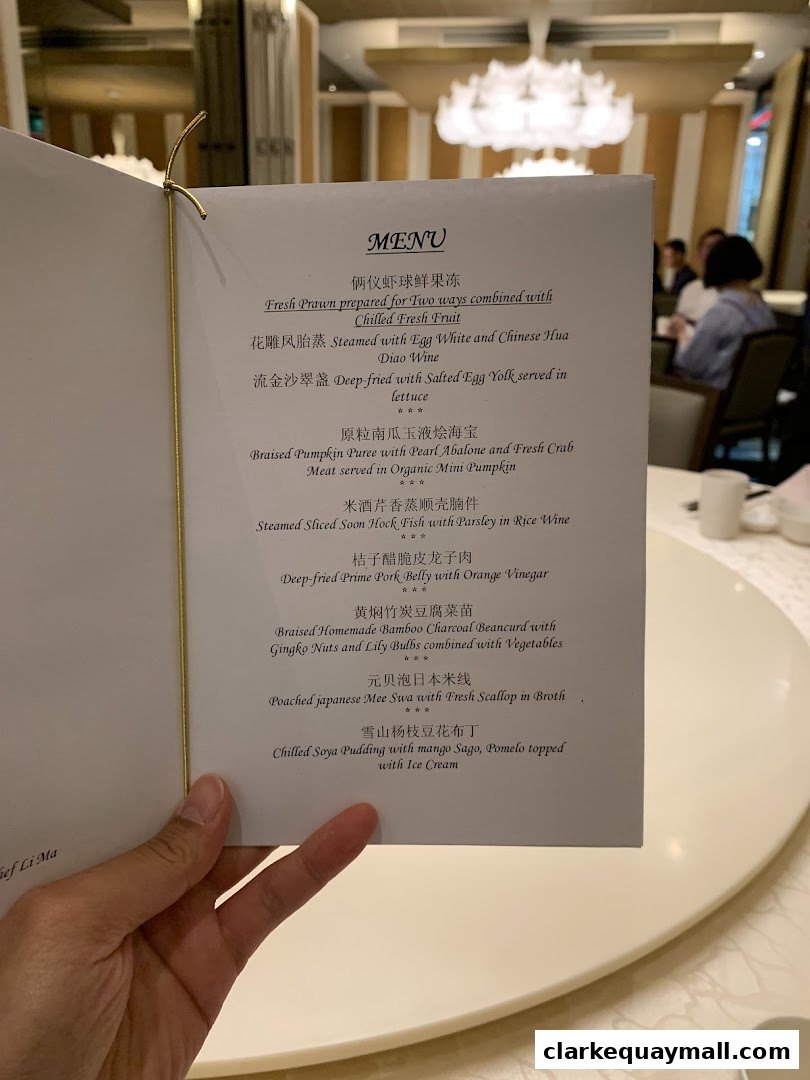 A hand holds open a menu at TungLok Signatures, showcasing various Chinese dishes.