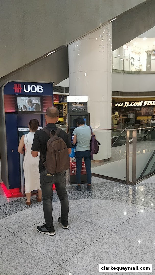 People using UOB ATM machines in a modern shopping mall.