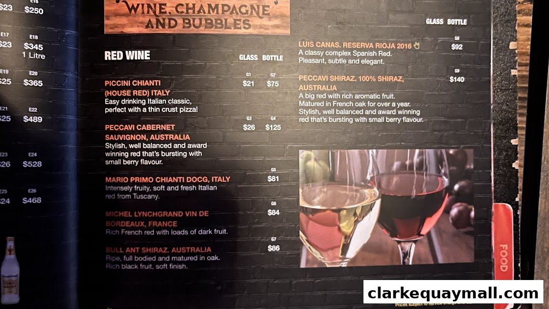 A menu page featuring red wines with descriptions and prices, alongside an image of two wine glasses.