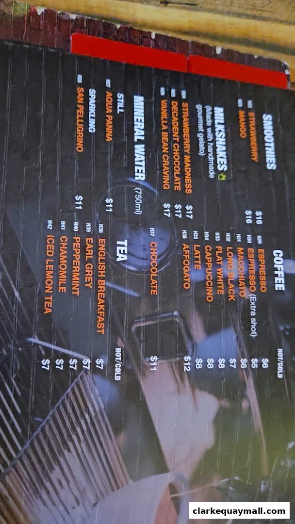 A menu displaying various drinks including coffee, tea, milkshakes, and smoothies with prices.