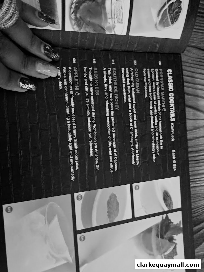 A close-up of a cocktail menu with detailed descriptions and images of drinks.