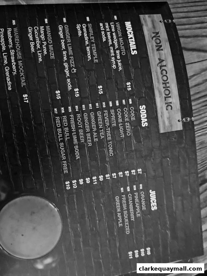 A black and white image of a menu featuring mocktails, sodas, and juices with prices.