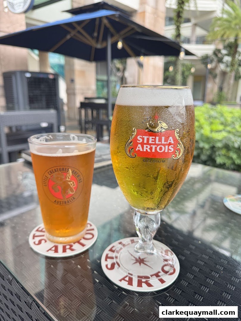 Two glasses of beer on a table with Stella Artois coasters.