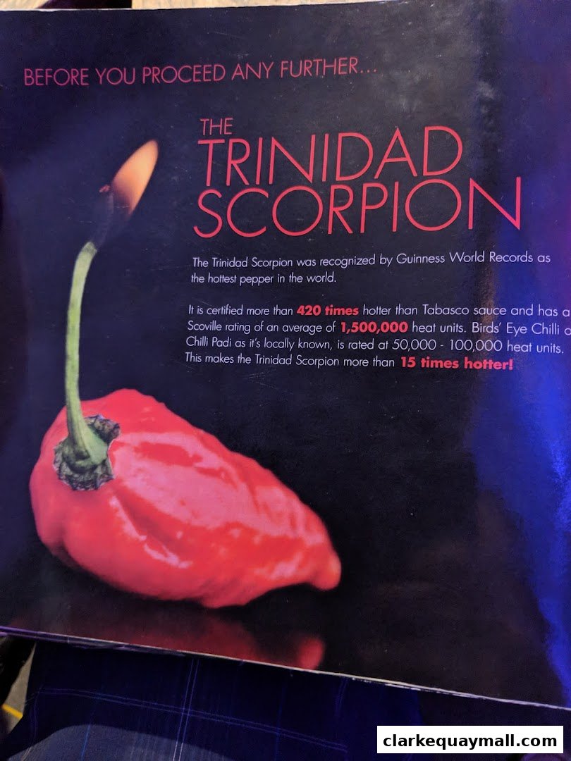 A close-up of a red Trinidad Scorpion pepper with text about its heat.