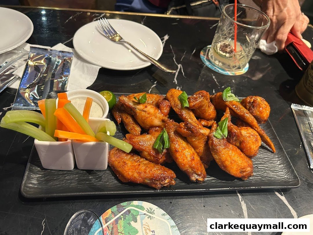 A platter of delicious chicken wings served with celery and carrot sticks and dipping sauce.