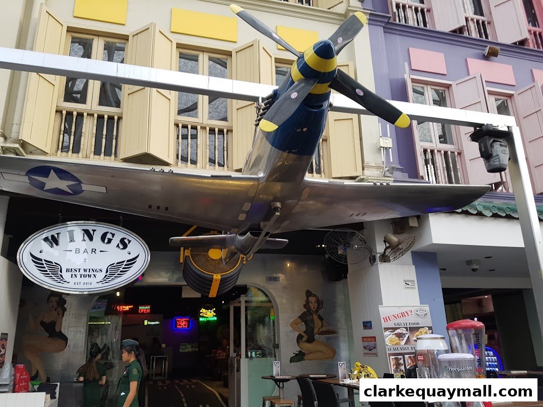 A bar and grill with a vintage airplane model suspended above its entrance.