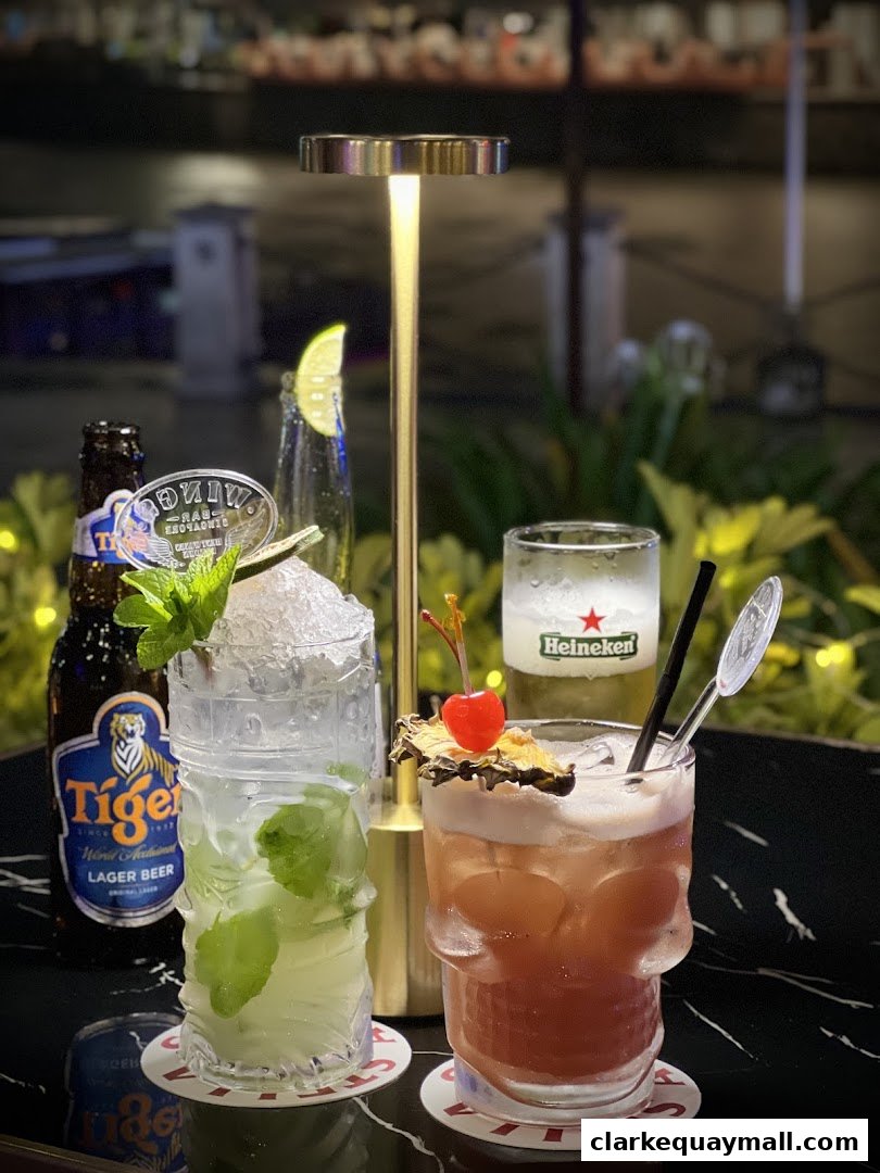Two refreshing cocktails and a bottle of Tiger beer are displayed on a table.