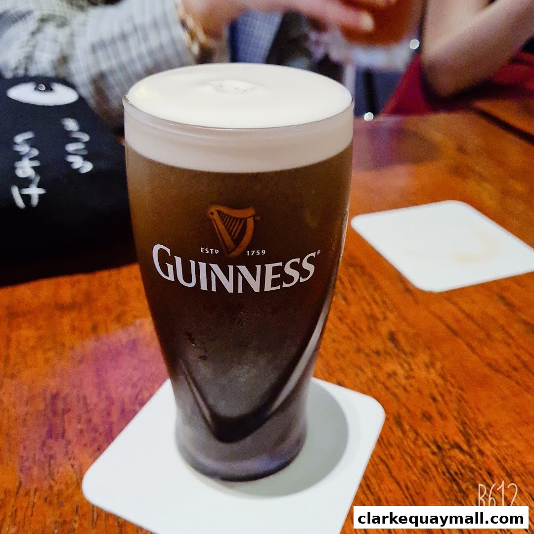 A close-up shot of a perfectly poured pint of Guinness on a wooden table.